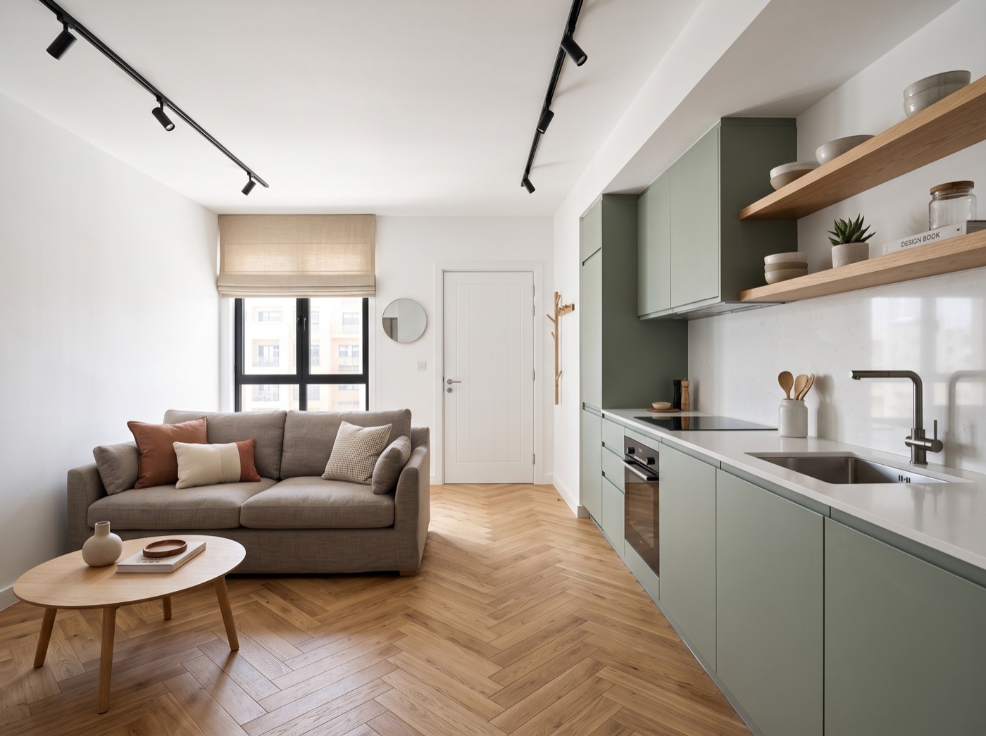 Same apartment after renovation — oak herringbone floor and sage-green kitchen